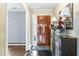 Elegant foyer with a wooden front door, decorative wallpaper, and a stylish console table at 5205 Rembert Dr, Raleigh, NC 27612