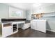 Functional laundry room with ample counter space, white cabinetry, washer, dryer, and natural light from the window at 5205 Rembert Dr, Raleigh, NC 27612