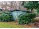 A vintage outdoor storage shed sits surrounded by lush greenery at 5205 Rembert Dr, Raleigh, NC 27612