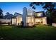 Exterior of white home featuring a brick chimney, an outdoor dining area, and manicured lawn at 1307 Mayfair Rd, Raleigh, NC 27608