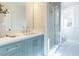 Modern bathroom with a walk-in shower, tiled floor, and light-blue vanity at 1307 Mayfair Rd, Raleigh, NC 27608