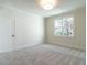 Simple bedroom with carpet, neutral walls, and a large window at 1307 Mayfair Rd, Raleigh, NC 27608