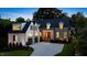 Elegant stone and white two-story home featuring a manicured lawn, dark roof, and attached garage at 1307 Mayfair Rd, Raleigh, NC 27608
