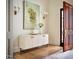 Modern foyer with white storage cabinet, hardwood floors, and decorative wall sconces at 1307 Mayfair Rd, Raleigh, NC 27608