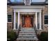 Elegant stone home featuring a covered front door with pillars, wooden door and glass sidelights at 1307 Mayfair Rd, Raleigh, NC 27608