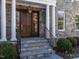 Elegant entryway with stone facade, columns, and a dark wood door at 1307 Mayfair Rd, Raleigh, NC 27608