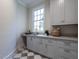 Laundry room with gray cabinets, quartz countertops, and a checkered floor at 1307 Mayfair Rd, Raleigh, NC 27608