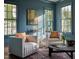 Inviting living room featuring blue walls, large windows, stylish seating, and a decorative rug at 1307 Mayfair Rd, Raleigh, NC 27608
