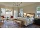 Inviting main bedroom with lots of natural light, hardwood floors, and designer chandelier at 1307 Mayfair Rd, Raleigh, NC 27608