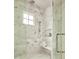 Luxurious walk-in shower with marble tile, a rainfall shower head, and a built-in bench at 1307 Mayfair Rd, Raleigh, NC 27608