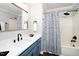 Stylish bathroom with blue vanity, black accents, and striped shower curtain at 1554 Middle Ridge Dr, Willow Springs, NC 27592