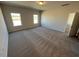 Carpeted bedroom illuminated by natural light from two windows, leading to an ensuite bathroom at 17 E Victory View Ter, Smithfield, NC 27577