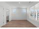 Bright bedroom featuring wood-look flooring, two windows, and an ensuite bathroom with modern fixtures at 2006 Anna Lilley Dr # 72, Fuquay Varina, NC 27526
