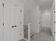 Second-floor hallway featuring carpet flooring, a wrought iron railing, and white doors at 2006 Anna Lilley Dr # 72, Fuquay Varina, NC 27526