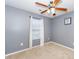 Simple bedroom with gray walls, ceiling fan and window at 2019 Tennessee Rd, Durham, NC 27704