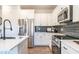 White kitchen with stainless steel appliances and dark gray backsplash at 216 Vili Dr, Broadway, NC 27505