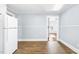 Bright kitchen with modern white refrigerator, wood floors, and a view into the next room at 2205 Lacy St, Burlington, NC 27215