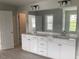 Bathroom featuring large mirror over dual vanity with white cabinets and modern fixtures at 310 N Maple Walk # 236, Garner, NC 27529