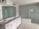 Bright bathroom with double sinks, white cabinets, soaking tub and glass shower enclosure at 310 N Maple Walk # 236, Garner, NC 27529