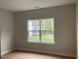 Bright bedroom with a view of the landscaped yard through the window at 310 N Maple Walk # 236, Garner, NC 27529