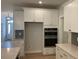 Modern kitchen featuring white cabinets, stainless steel appliances, and a built-in double oven at 310 N Maple Walk # 236, Garner, NC 27529