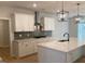 Beautiful kitchen with white cabinetry, quartz countertops, and a stainless steel range hood at 310 N Maple Walk # 236, Garner, NC 27529