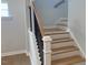A wooden staircase with a white banister and black balusters at 310 N Maple Walk # 236, Garner, NC 27529