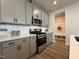 Stylish kitchen with gray cabinetry, white backsplash, stainless steel appliances and mudroom access at 600 Hillfarm Dr, Wake Forest, NC 27587