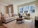 Cozy living room with stylish furniture, a patterned rug, and ample natural light through large windows at 600 Hillfarm Dr, Wake Forest, NC 27587