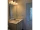 Bright bathroom featuring a well-lit vanity with white cabinetry and a framed mirror at 65 Vili Dr, Broadway, NC 27505