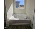 Bathroom featuring a drop-in tub with a window view and sleek chrome fixtures at 87 Vili Dr, Broadway, NC 27505