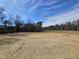 Cleared lot ready for construction with wooded backdrop and sunny blue skies at 87 Vili Dr, Broadway, NC 27505