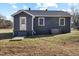Rear view of house with gray siding and landscaping at 909 E F St, Butner, NC 27509
