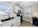 Well-equipped kitchen with black appliances and white cabinets at 909 E F St, Butner, NC 27509