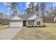 House exterior featuring stone and siding, a two-car garage, and landscaping at 101 Prairie Dog Dr, Louisburg, NC 27549