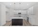 Modern kitchen with island, white cabinets, and pendant lighting at 101 Prairie Dog Dr, Louisburg, NC 27549
