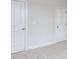 Neutral bedroom with light-colored carpet, white baseboards, two white doors, and a light switch at 108 Bearwallow Forest Way, Wendell, NC 27591