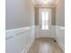 Bright entryway with light hardwood floors, white wainscoting and a glass-paneled front door at 108 Bearwallow Forest Way, Wendell, NC 27591