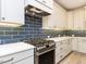 Close up of modern kitchen with stainless steel stove and blue tiled backsplash at 108 Bearwallow Forest Way, Wendell, NC 27591