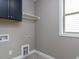 Laundry room with grey walls, tile floors, and a window at 108 Bearwallow Forest Way, Wendell, NC 27591