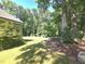 Lush back yard surrounded by trees with a lawn and landscaping adjacent to the home at 109 Springwood Dr, Wake Forest, NC 27587