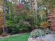 Secluded backyard features lush trees with seasonal foliage, and landscaped plant and flower beds at 109 Springwood Dr, Wake Forest, NC 27587