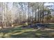 Landscaped backyard with fire pit and surrounding woods at 109 Springwood Dr, Wake Forest, NC 27587