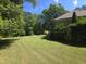 Expansive backyard features a well-maintained lawn and a deck next to the house at 109 Springwood Dr, Wake Forest, NC 27587