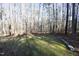 Spacious backyard with wooded area and stone retaining wall at 109 Springwood Dr, Wake Forest, NC 27587