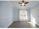 Bright bedroom features a ceiling fan, light blue walls, trim accents, and wood-look flooring at 109 Springwood Dr, Wake Forest, NC 27587