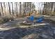 Relaxing fire pit area with stone patio and two blue chairs at 109 Springwood Dr, Wake Forest, NC 27587
