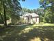 Traditional-style home with a lush lawn, mature trees, and a charming front garden at 109 Springwood Dr, Wake Forest, NC 27587