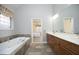 Bright main bathroom with soaking tub, double vanity, and view into the main bedroom at 109 Springwood Dr, Wake Forest, NC 27587