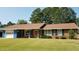 Brick ranch home with attached garage, mature trees, and well-manicured lawn at 1408 Kenbrook Dr, Garner, NC 27529